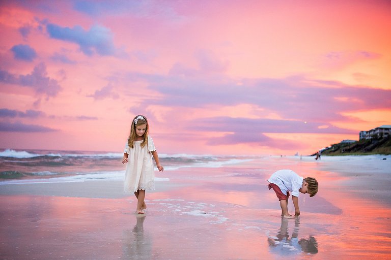 Two Kids play on the beach in Rosemary Beach FLorida with a pink and purple sunset by 30a photographer two lights photography